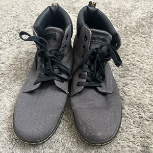 Dr Martens high top grey shoes with black bottom.